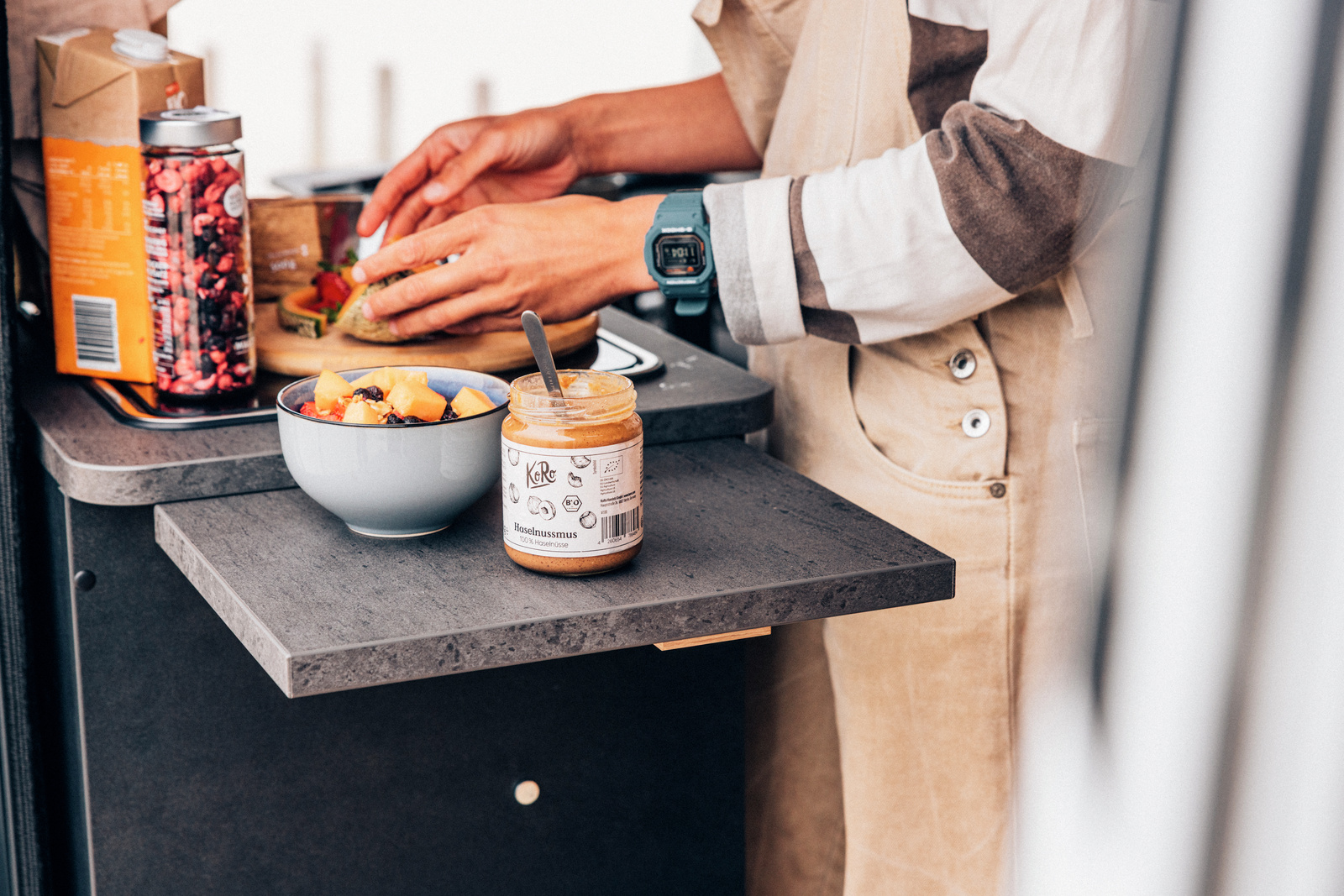 Fruit and a simple meal being prepared on a campervan kitchen counter