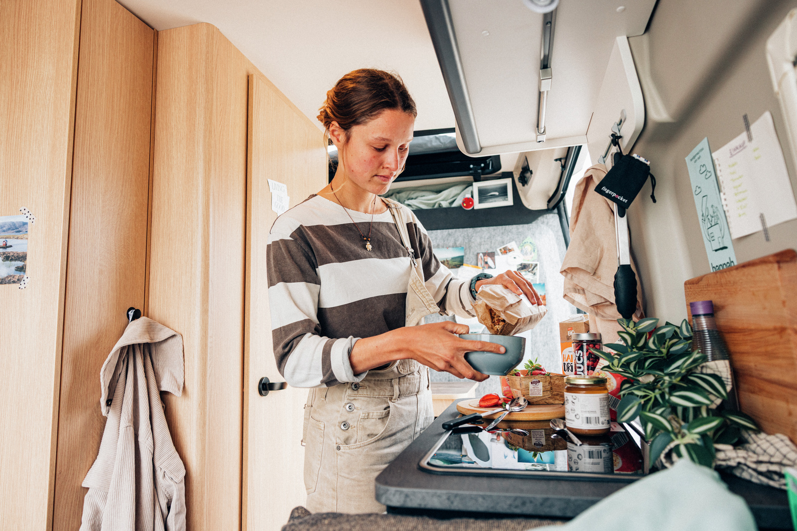 A traveler preparing a meal in the campervan kitchen